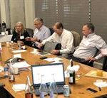 Group of people in a meeting sitting around a table