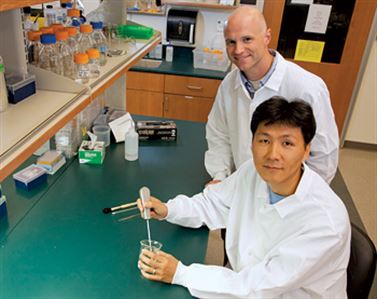 William L. Murphy and Jae-Sung Lee working in a lab