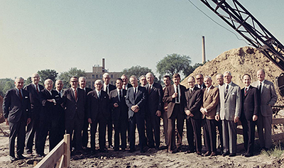 A group of people standing outside at construction sitein 1969