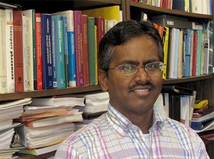 Sundaram Gunasekaran standing in front of a full bookcase