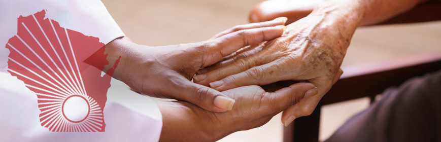 A closeup of a younger person holding an elderly person's hand